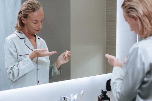 woman in the bathroom looks at herself in the mirror
