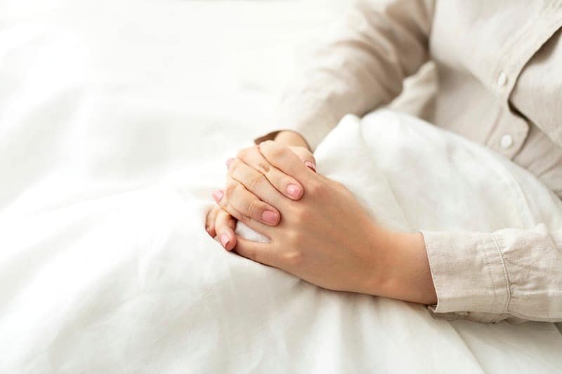 faithful woman praying in bed